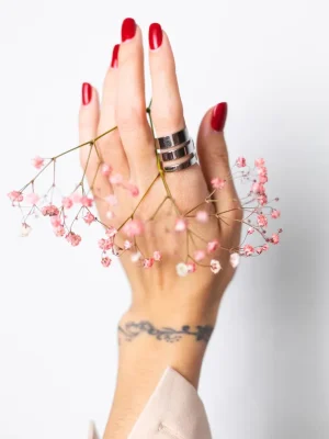 soft-gentle-photo-woman-hand-with-big-ring-red-manicure-hold-cute-little-pink-dried-flowers-white_343596-3263 tratamientos de belleza en Bilbao
